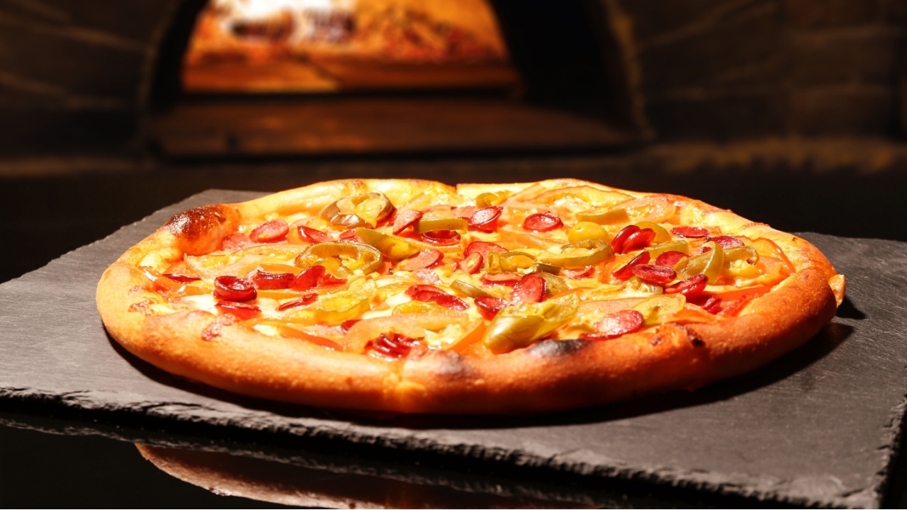 Freshly baked pizza on table against oven
