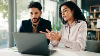 People, talk and meeting with laptop in office for finance report, ideas and investment pitch. Staff, explain and document with team for profit growth, revenue and chart results of financial proposal