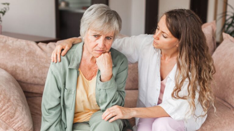 Loving adult daughter talking to sad old mother holding hand comforting upset older woman having problem, young caregiver helping senior patient, support, empathy and care to elderly parent concept