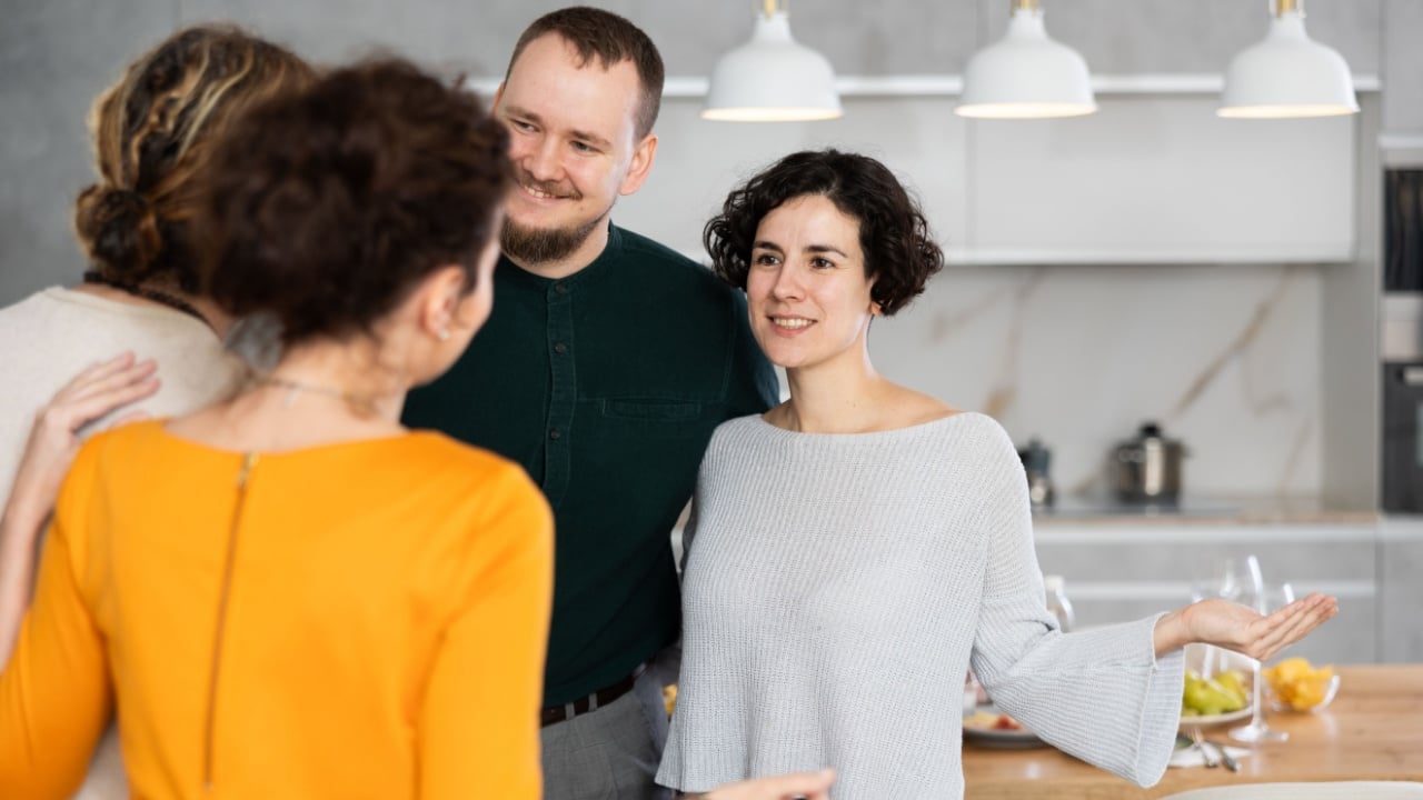 Married couple welcoming guests for dinner party at home