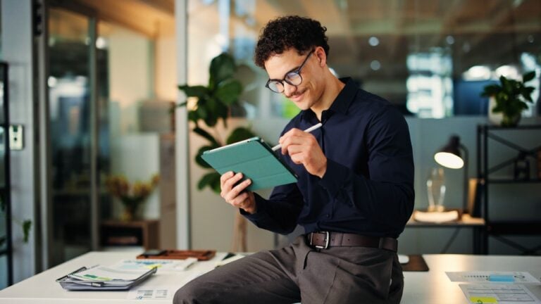 Happy man, web designer and night with tablet for online website, design or development in office. Creative, businessman or working late with technology for schedule, review or planning in workplace