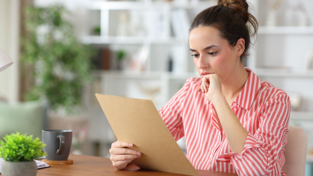 Attentive self employed reading paper document working at home