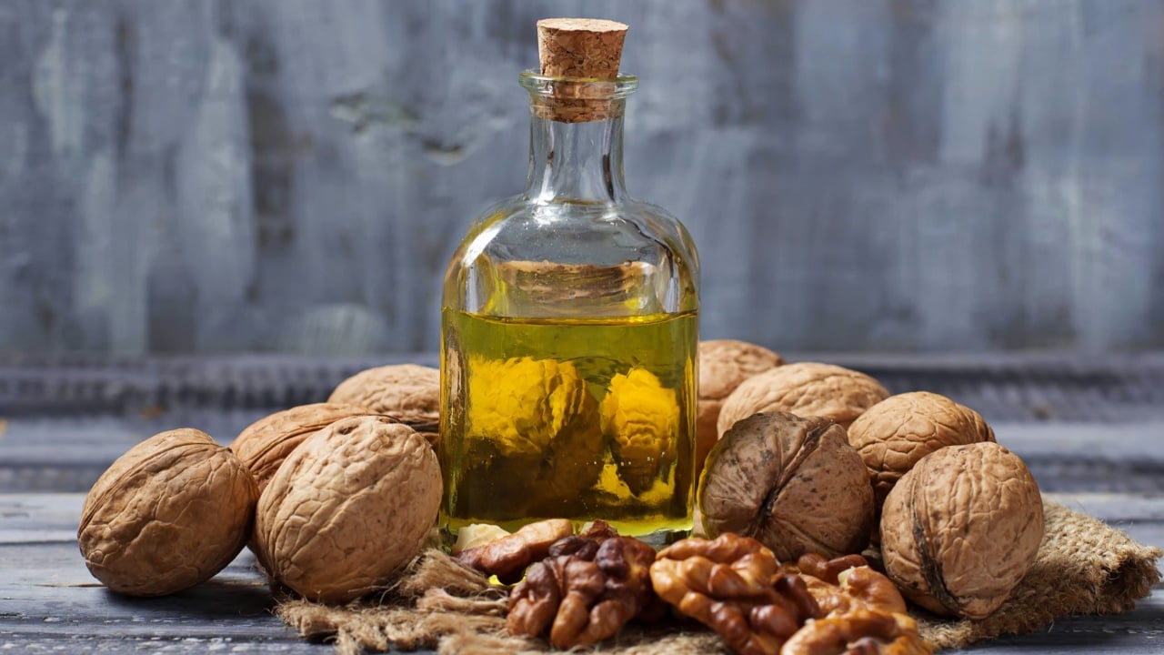 Walnut oil in bottle and nuts. Selective focus