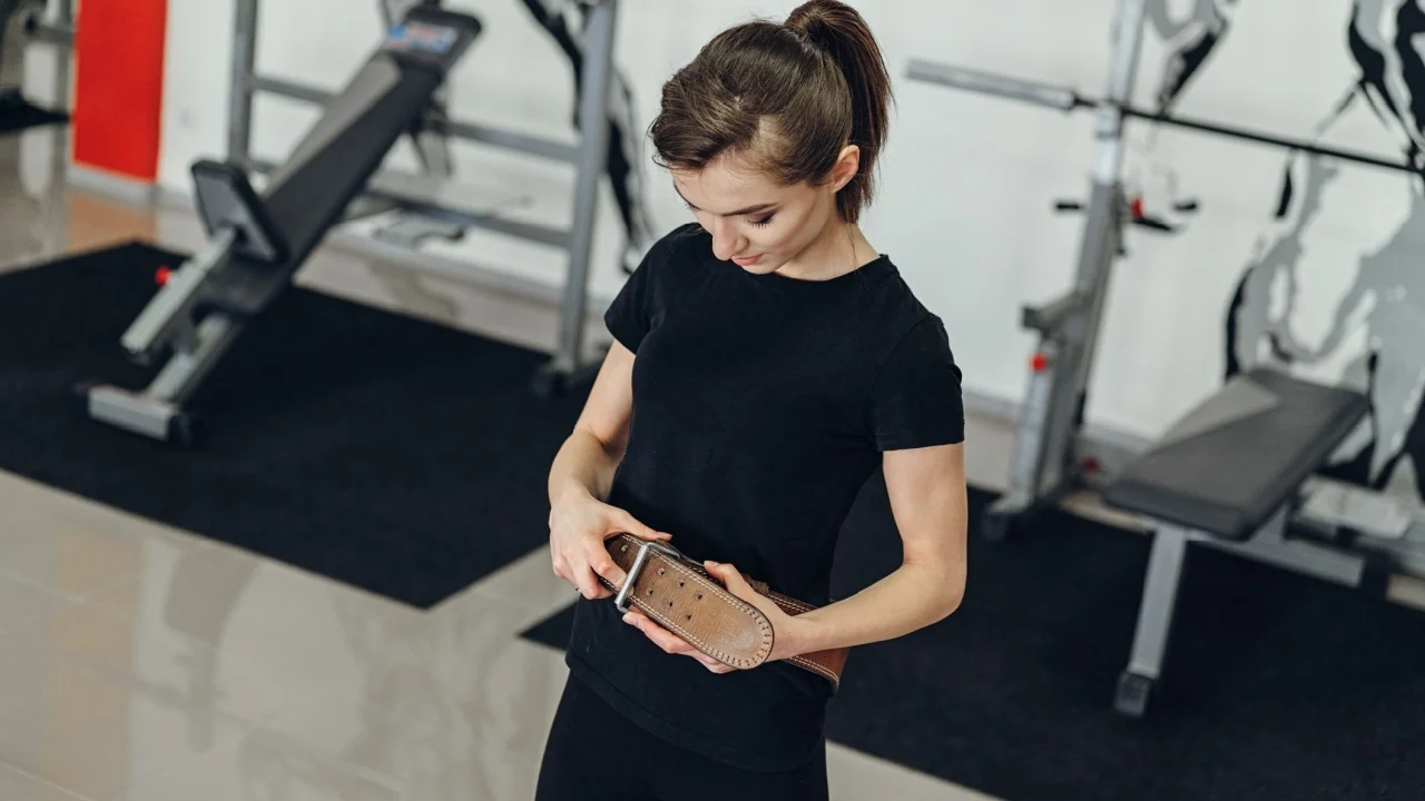 Beautiful girl in the gym with a belt