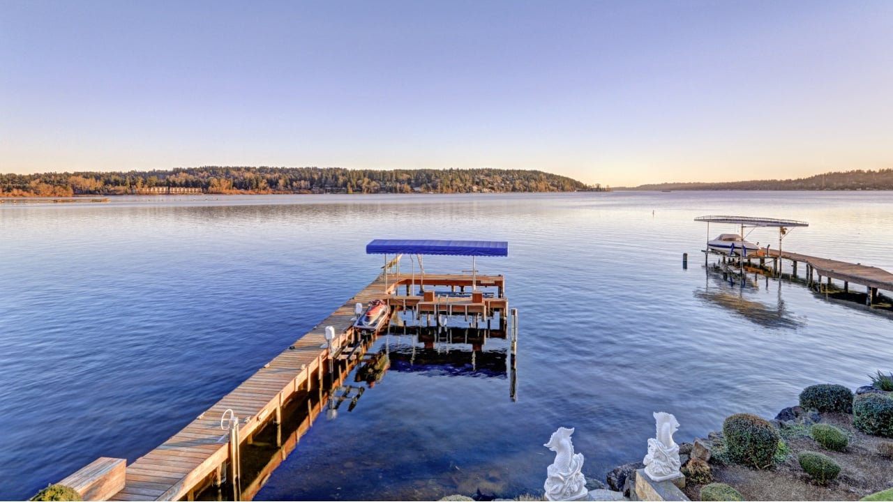 Private dock of waterfront home with jet ski lifts and covered boat lift, Lake Washington. Top view from the balcony of master bedroom. Northwest, USA