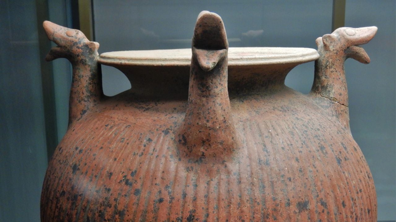 Ribbed olla in red body ceramic with four griffin prothromes. The olla is part of the grave goods of the Tomb of the Flabelli and was intended for mixing water and wine, closely linked to the practice of banquets. The tomb found between 1966 and 1968 is dated to the 7th century BC.