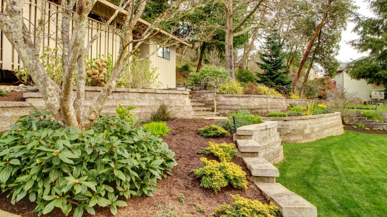 Early Spring Landscape with retaining walls and garage on the back.