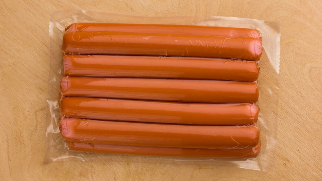 Sausages vacuum packed on a wooden surface. A bundle of sausages from the store on a wooden table.