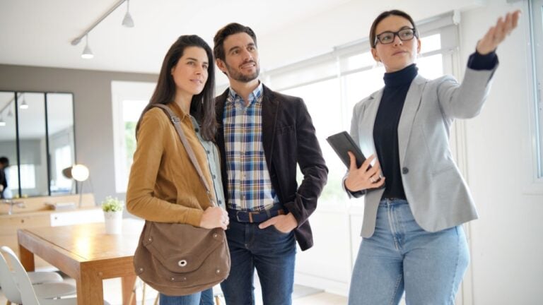 Real estate agent showing modern house to attractive couple