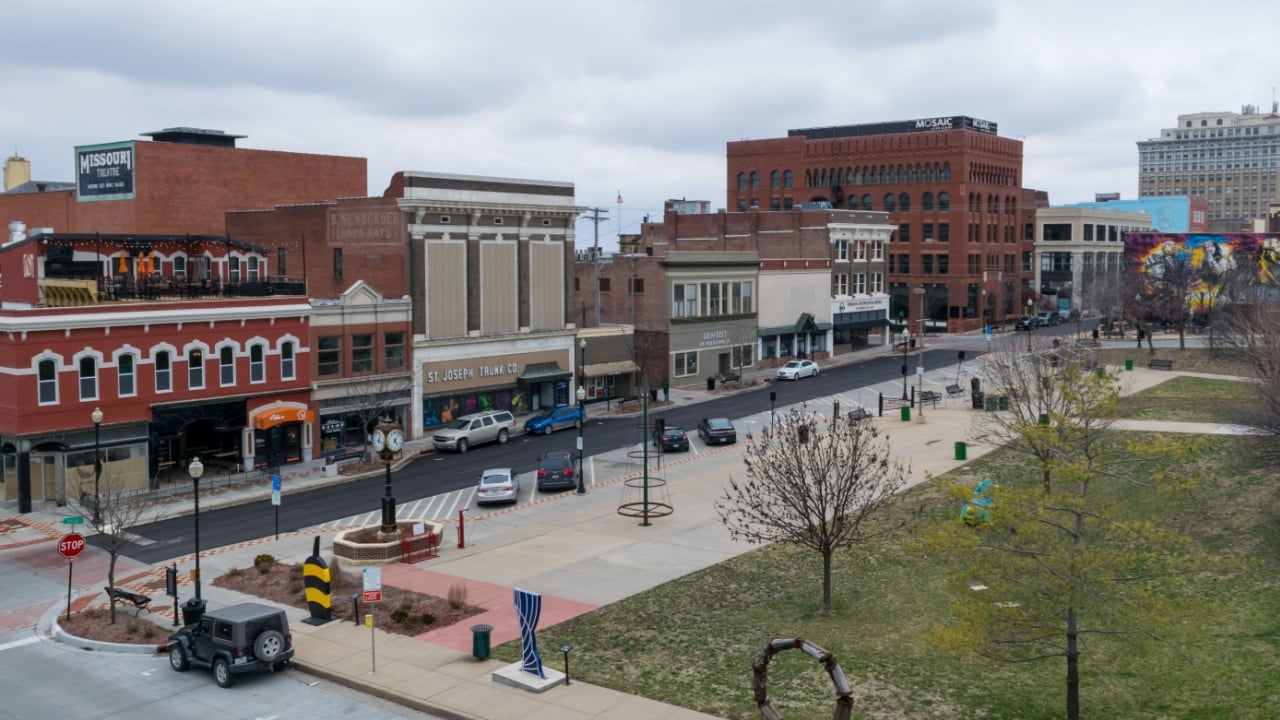 St. Joseph, Missouri United States of America - March 24 2019: Felix Street Square in downtown St. Joseph. View of cars parked, sculptures, and local business in the background.