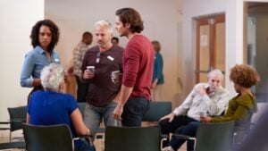 Group Of People Socializing After Meeting In Community Center