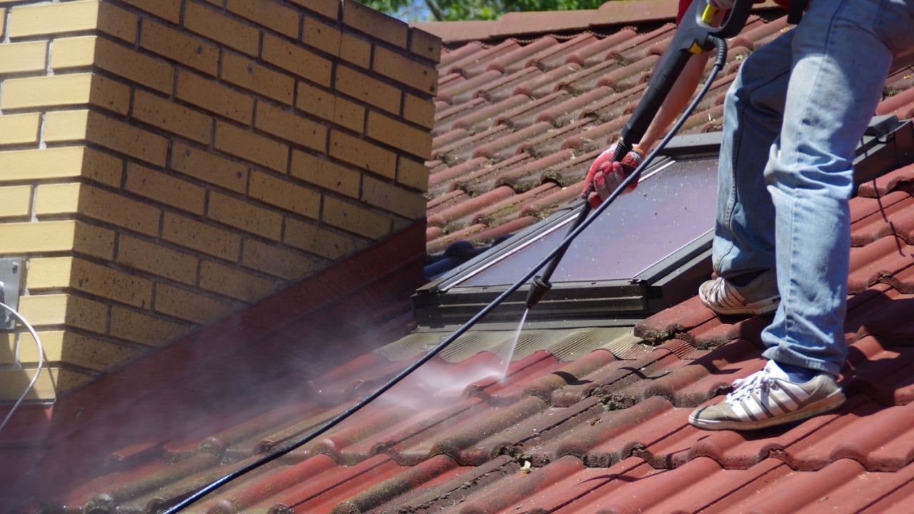 House roof cleaning with pressure tool. Moss removing with water. Tile washing with professional equipment.