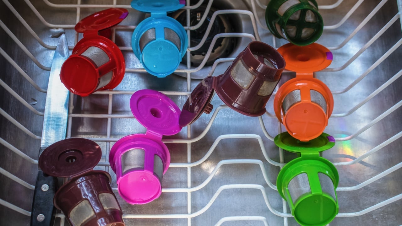 Stainless steel sink with dish drainer drying brightly colored refillable coffee pods