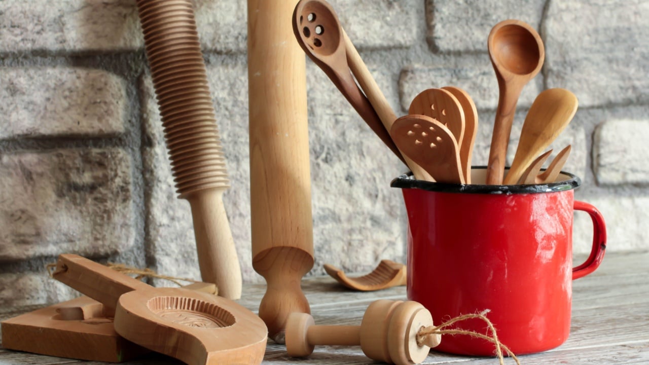 Wooden tools for working with dough. Rolling pins, spoons, cookie cutters and enameled mug for measuring flour