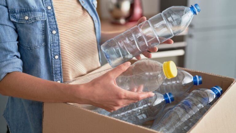Woman preparing plastic bottles for recycling