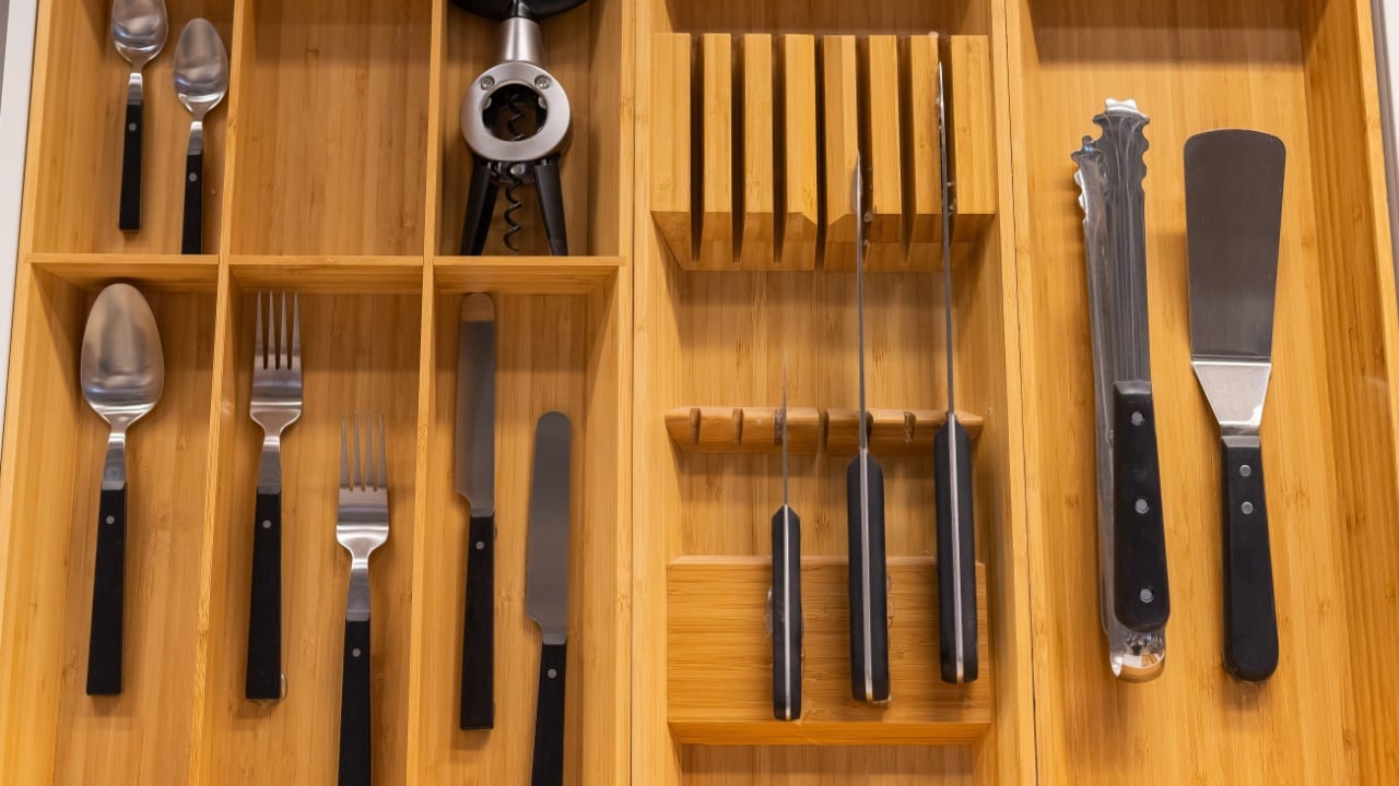 Top view of cutlery in a wooden box of a kitchen unit
