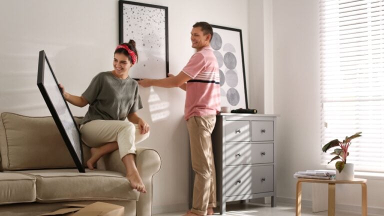Couple decorating room with pictures together. Interior design