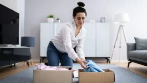Woman Decluttering Clothes, Sorting And Cleaning Up