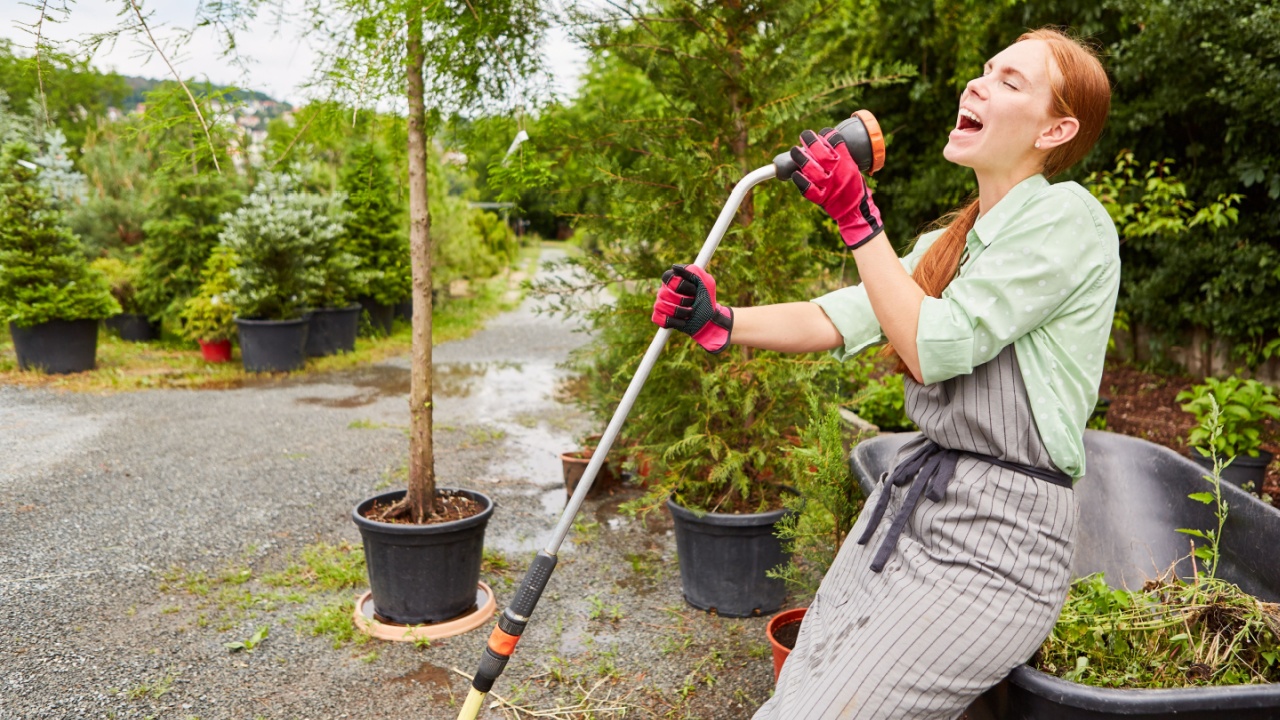 Gardener sings into a hose for joy in gardening for fun