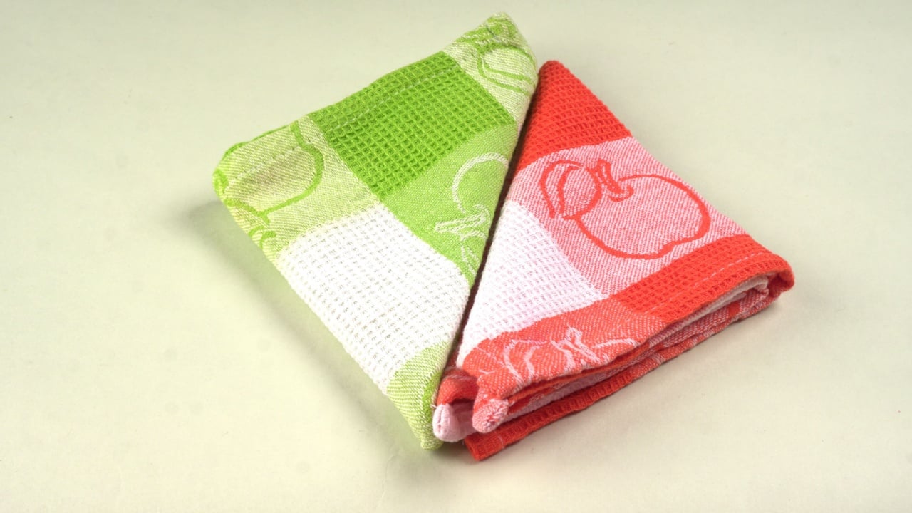 Folded kitchen textile towels of different colors, Household cleaning cloth. Closeup of cleaning rag isolated on a white background.