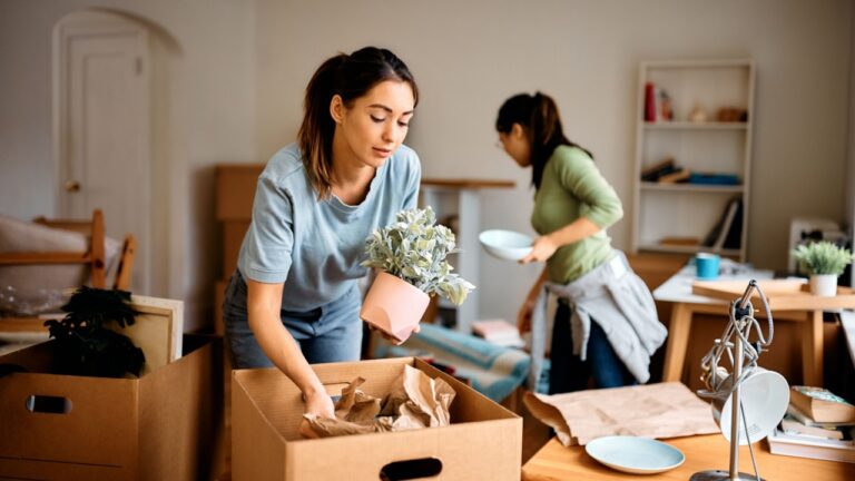 Female friends unpacking their things while moving into a new home.