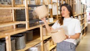 Positive latino american woman choosing original decorative wicker baskets in shop