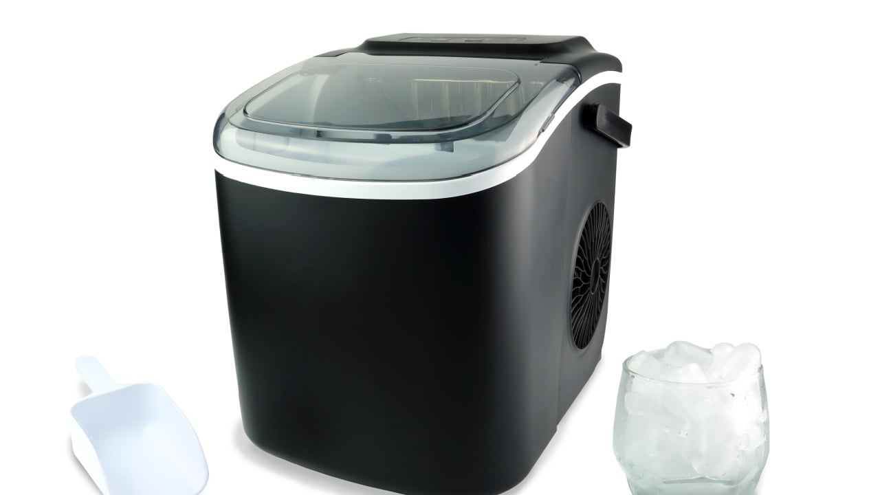 black modern design ice maker is used for making clean ice for various kinds of soft drink during summer on white table with a scoop and a glass of ice isolated on white background ( clipping path )