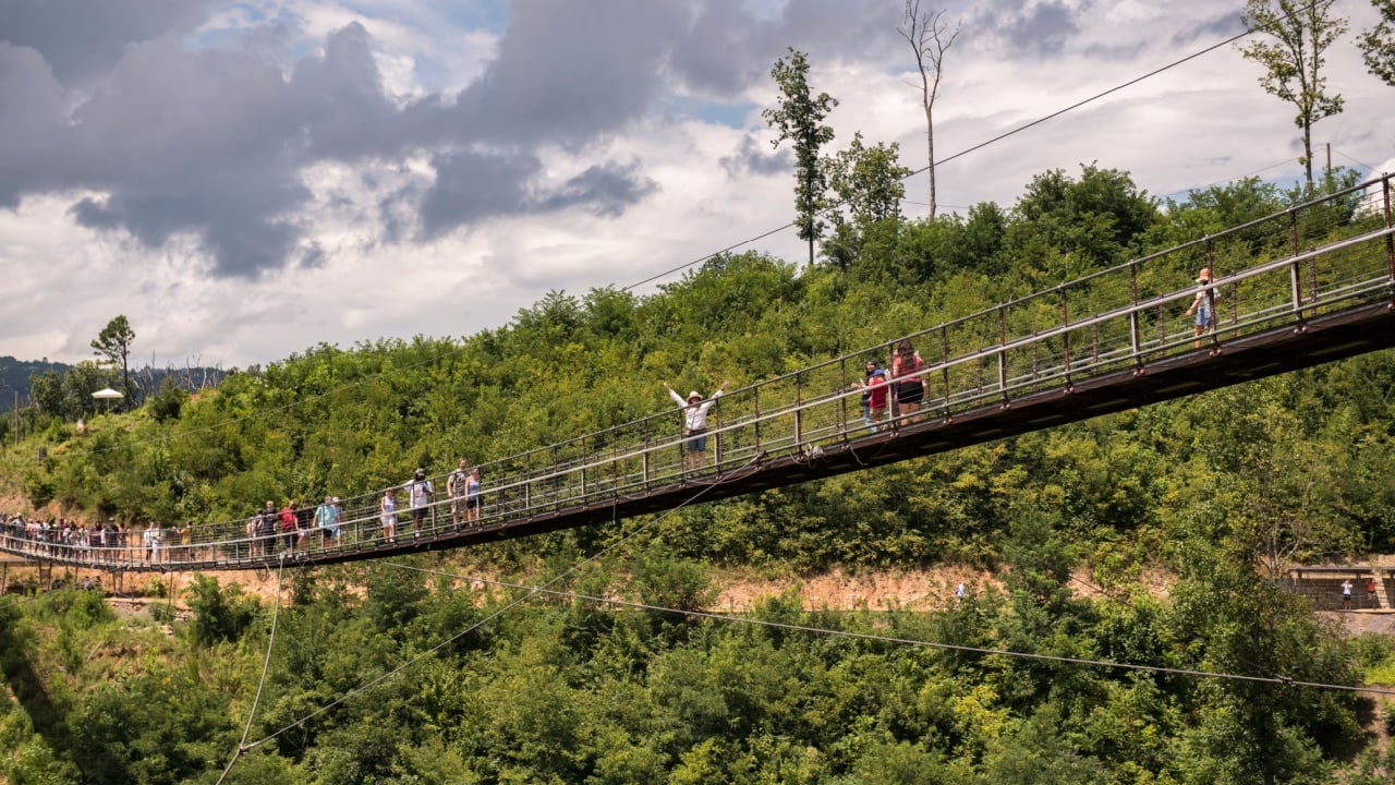 GATLINBURG, US - Jan 10, 2022: The Gatlinburg SkyBridge suspension bridge in Gatlinburg Tennessee with people walking on it and greenery around