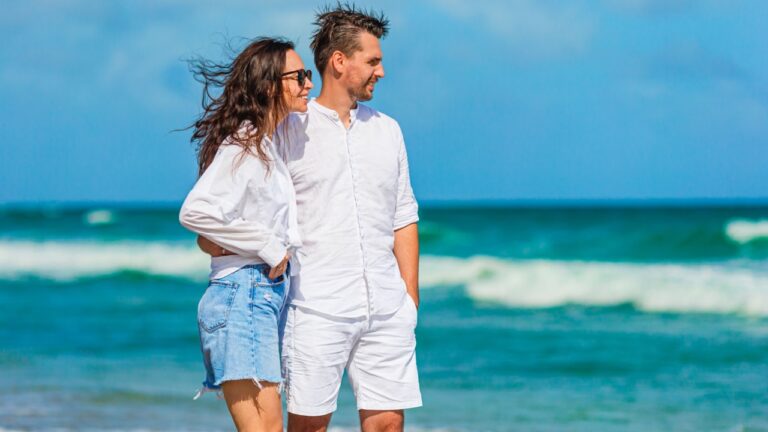 Young couple holding hands walking on the beach vacation