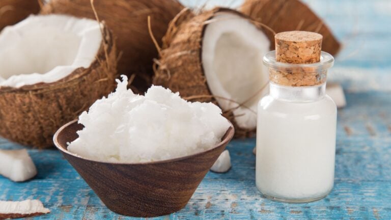 Coconut and coconut oil on old wooden table, close-up