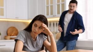 Stressed wife trying to ignore her angry husband in kitchen, selective focus. Relationship problems