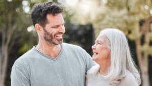 Hug, man and senior mom in garden with smile, gratitude and care with outdoor bonding together. Love, elderly mother and adult son in backyard with embrace, support and happy family laughing in park