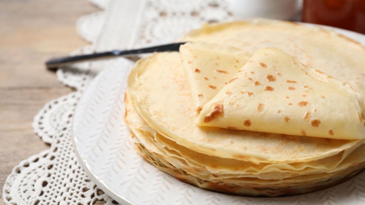 Stack of delicious crepes on table.