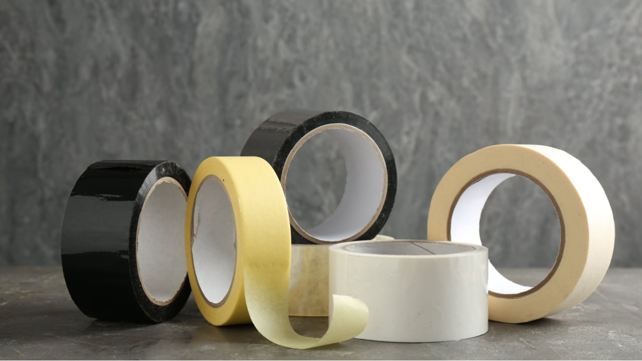 Rolls of different adhesive tapes on grey table
