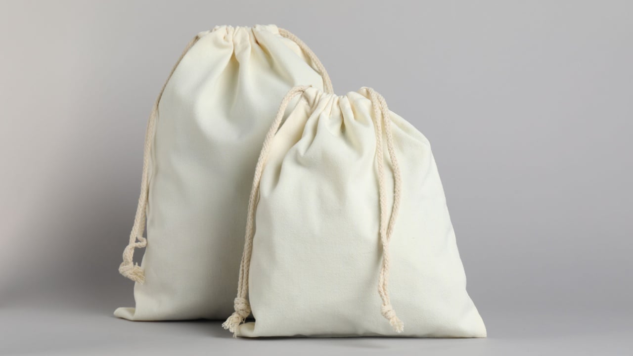 White cotton bags with ties on light grey background