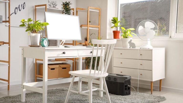 Comfortable workspace with modern computer and portable power station in contemporary room