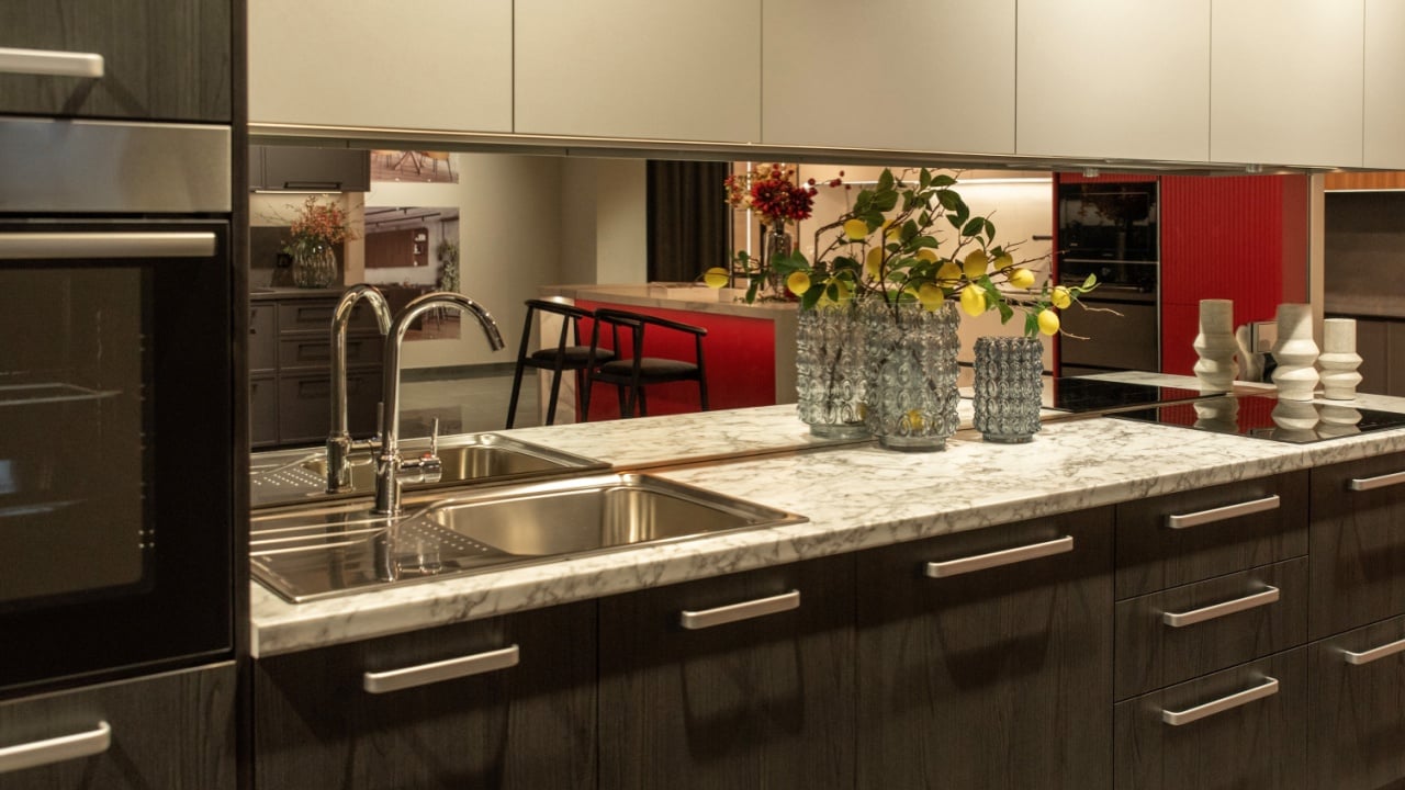 Chrome faucet with mirrored backsplash and sink in a kitchen