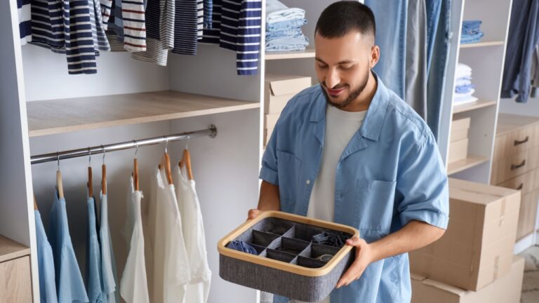 Young man with organizer in wardrobe