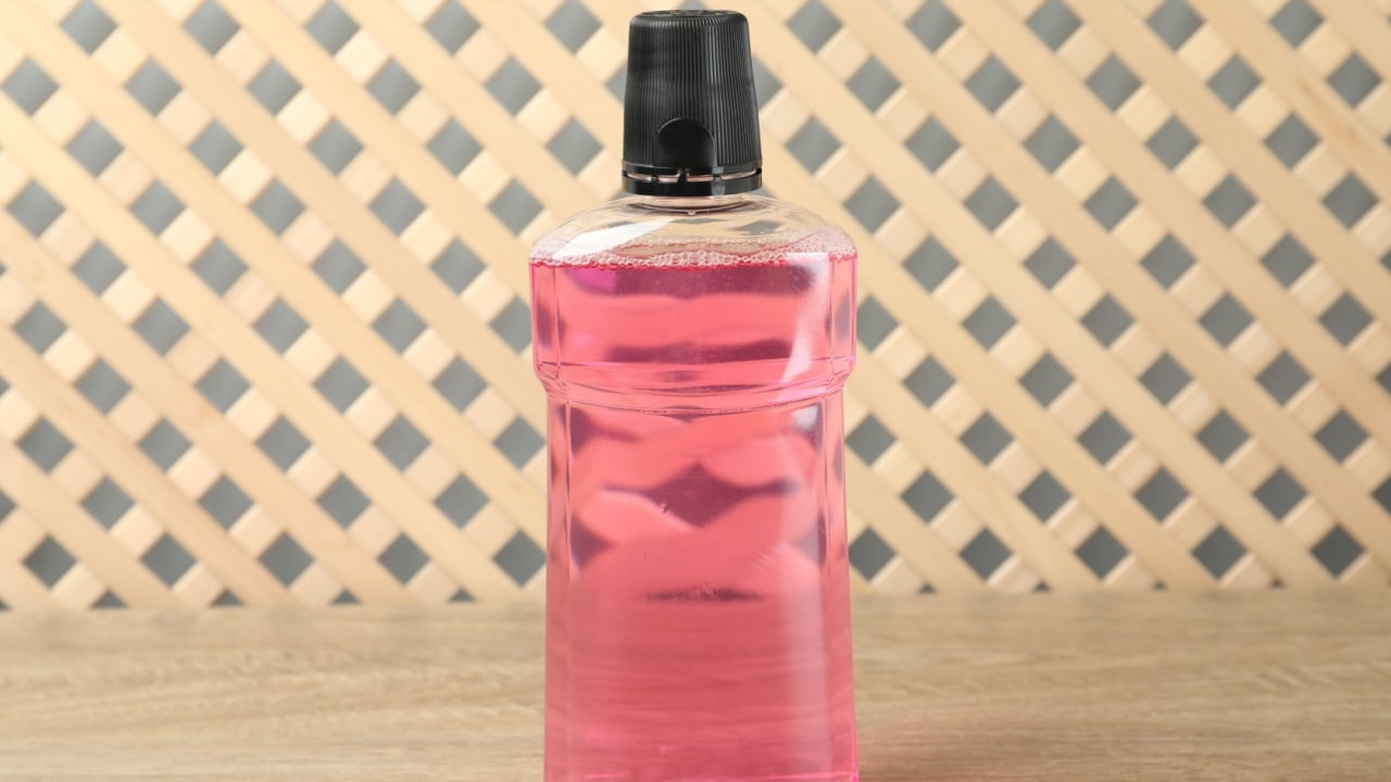Bottle of mouthwash on wooden table. Oral hygiene
