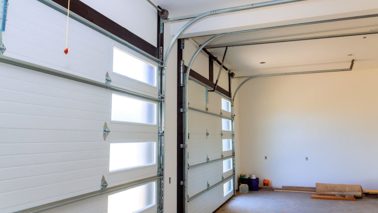 Spacious garage with large windows in doors, ideal for car storage workshop setup.