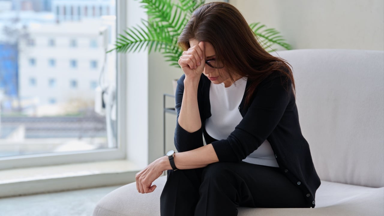 Mature sad woman experiencing stress, mental and physical pain, at home