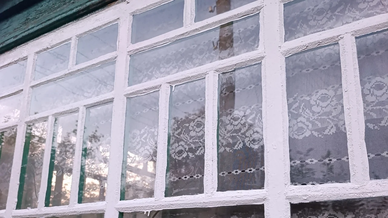 A window with lace on the side of a building.