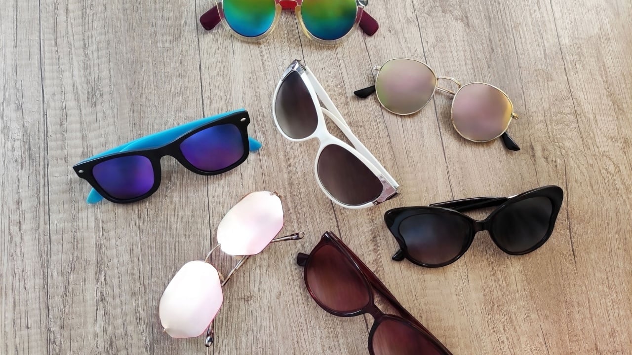 Women's multi-colored sunglasses on a light wooden background