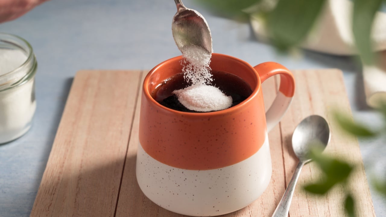 Pouring sweetener powder in cup of coffee. Sugar alternative, food and nutrition