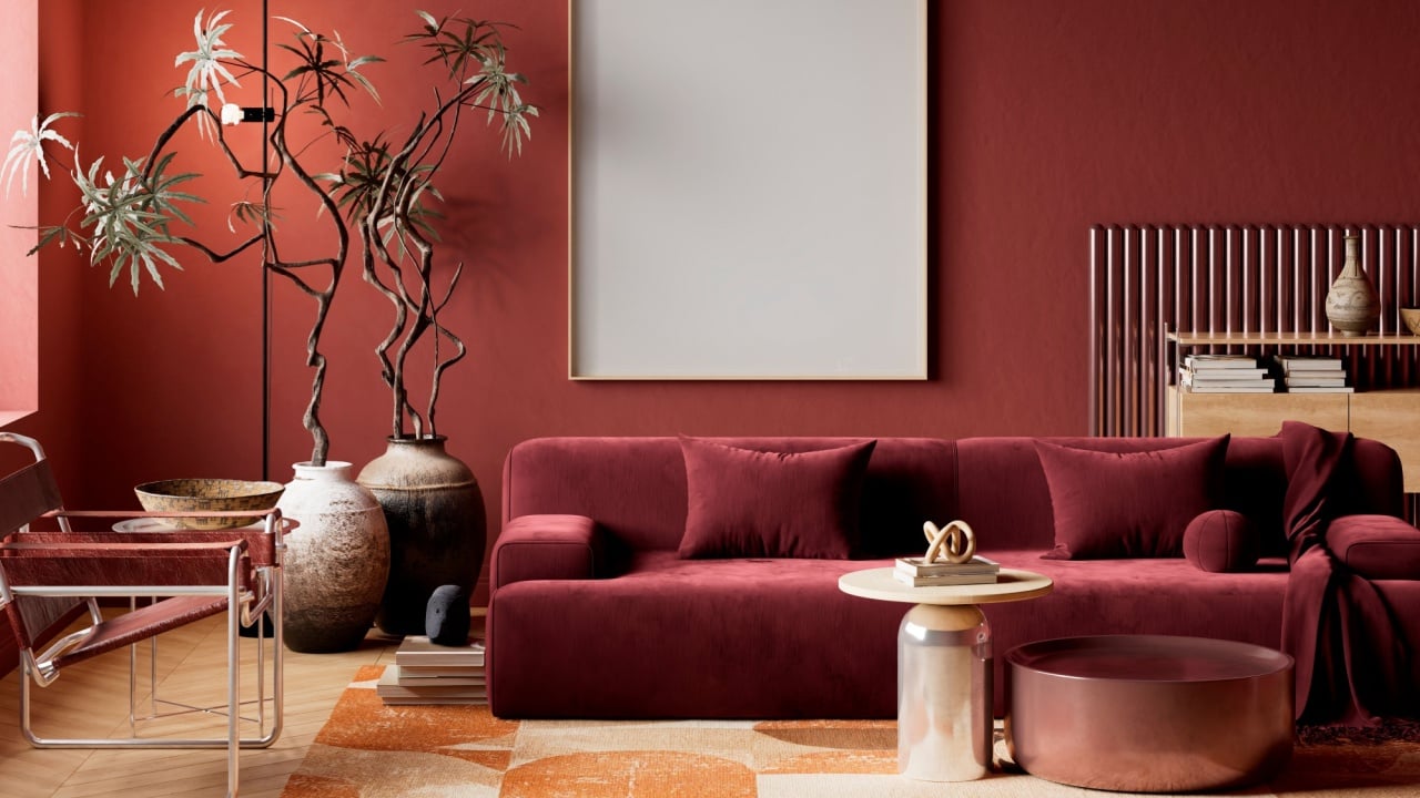Dark moody red living room with blank poster frame mockup and cinematic lighting creating luxury contemporary interior scene for premium presentation use.