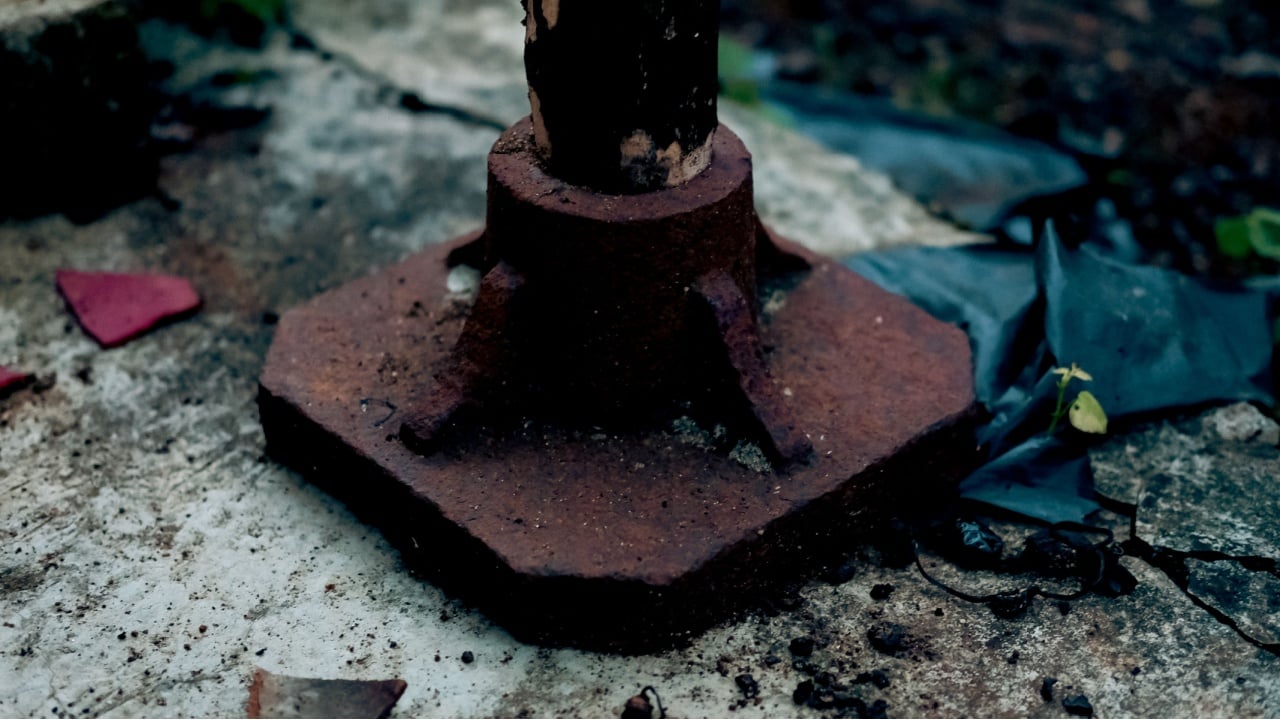A hand-held steel compactor used to manually compact and level the soil by repeatedly striking it.