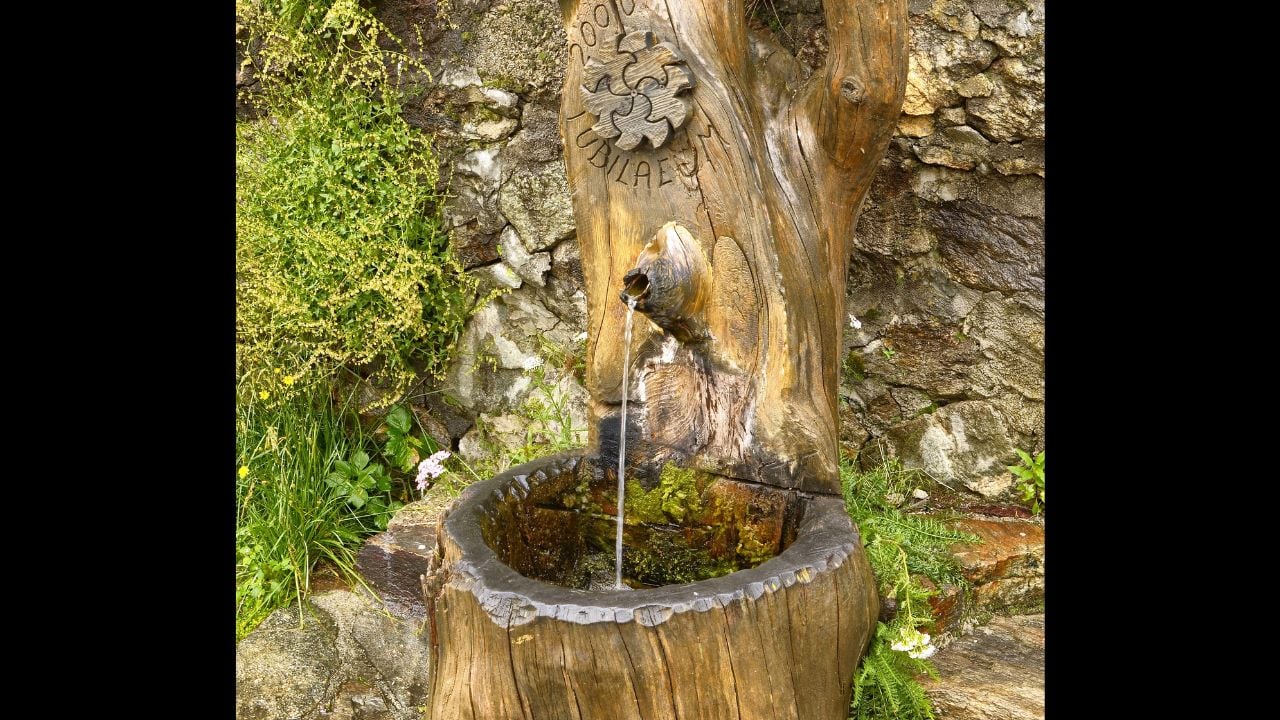 S. Anna di Vinadio, Piedmont, Italy. July 2019. A drinking water fountain made of artistically carved wood.