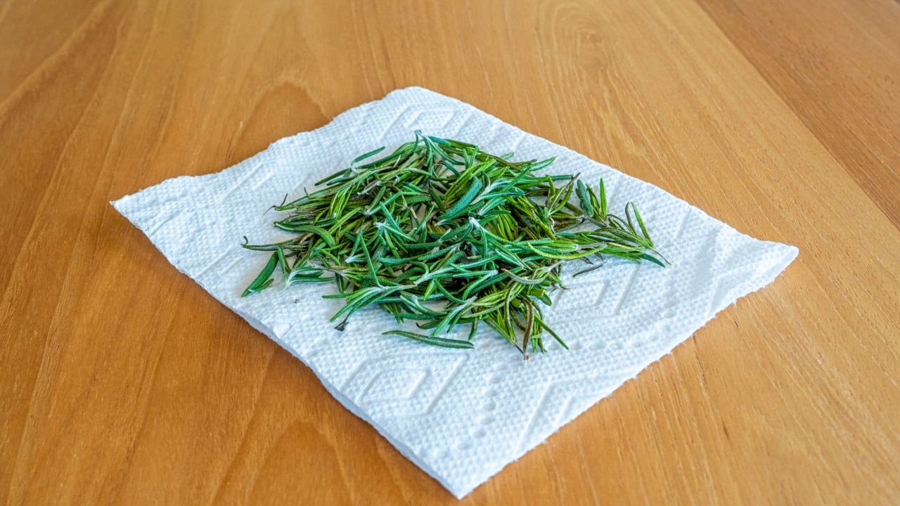 Aromatic Fresh rosemary drying on a paper towel on a hardwood background