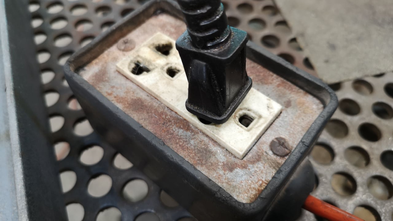 Plug the black into an electrical socket on the metal table.
