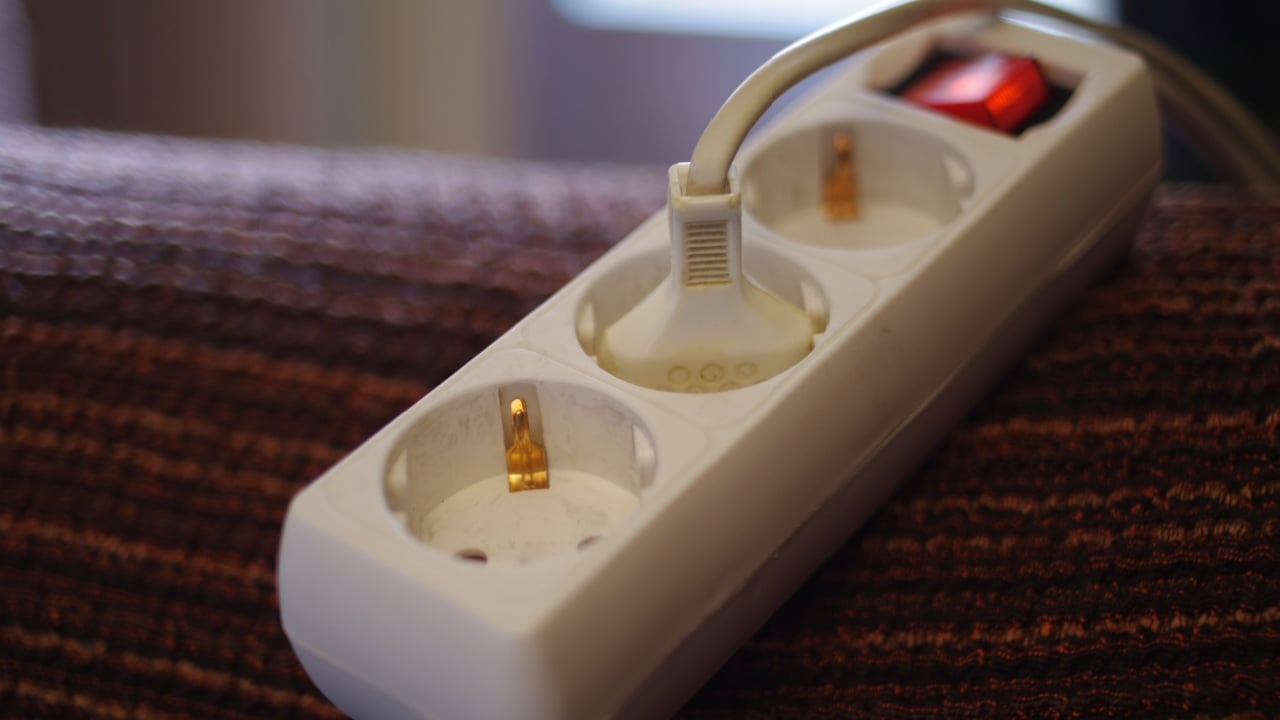 Multiple plug socket at home on a chair, with a blurry background.